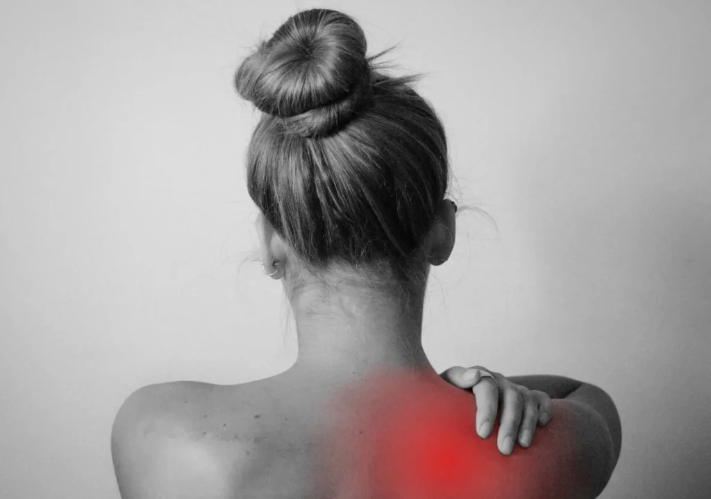 Mujer con dolor y tensión en la zona cervical y hombros, representación visual de las molestias musculoesqueléticas asociadas a la fibromialgia
